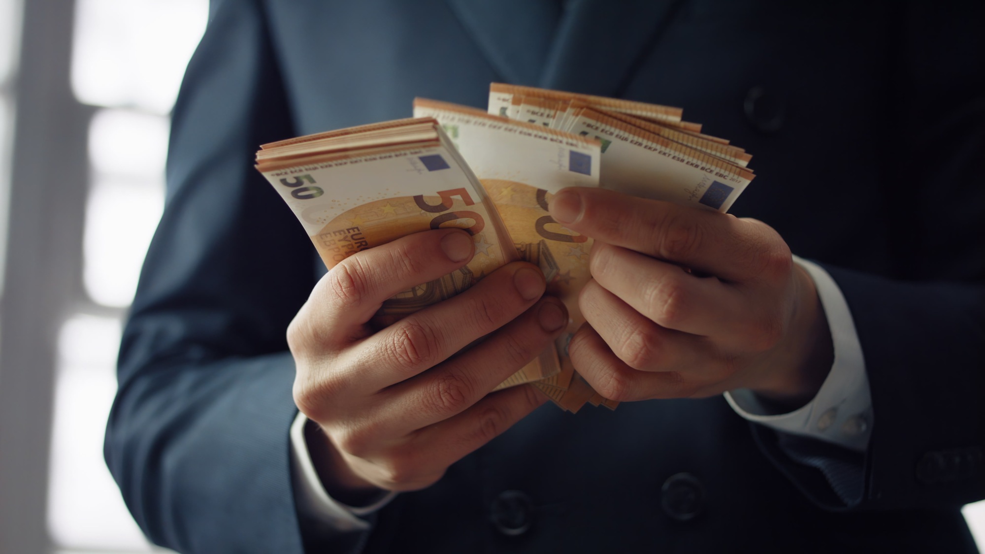Businessman counting euro bills close up. Man hands holding european currency.